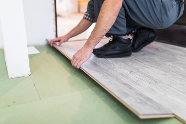 worker-processing-floor-with-laminated-flooring-boards_231208-4211